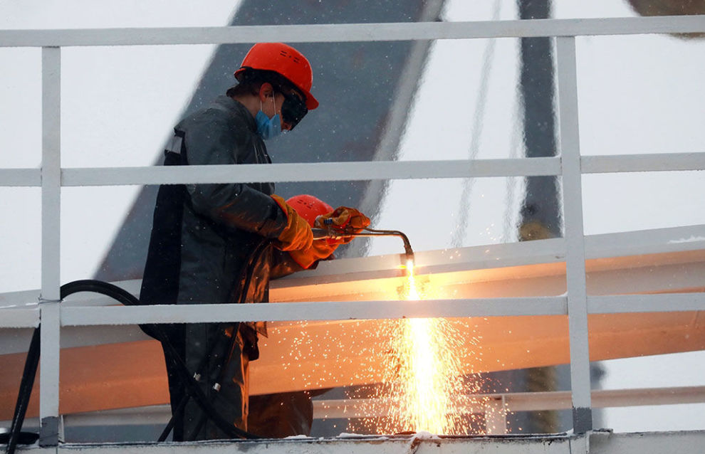 An Admiralty Shipyards worker cuts the snubbing line during the launch of the Severny Polyus ice-resistant self-propelled platform (Project 00903) in St. Petersburg