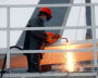 An Admiralty Shipyards worker cuts the snubbing line during the launch of the Severny Polyus ice-resistant self-propelled platform (Project 00903) in St. Petersburg
