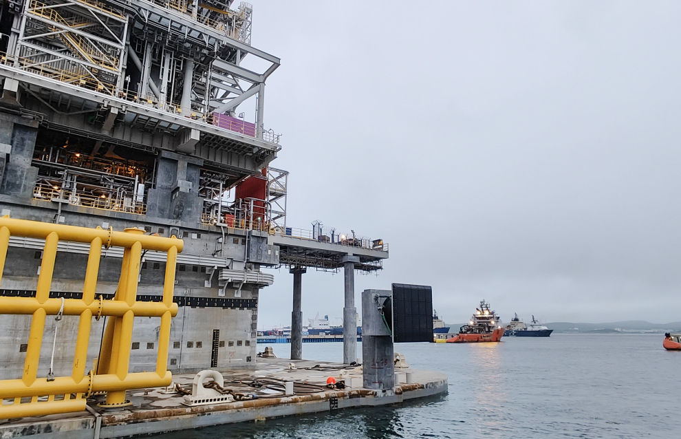 A tugboat tows the LNG production platform from the dry dock at the Novatek‒Murmansk LNG Construction Center