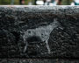 Carving petroglyphs on the sidewalk edging