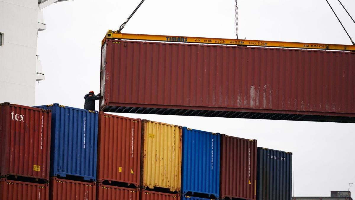 A crane loads containers at a seaport
