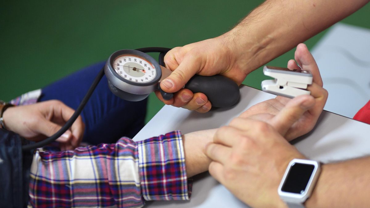 A doctor takes a patient’s blood pressure