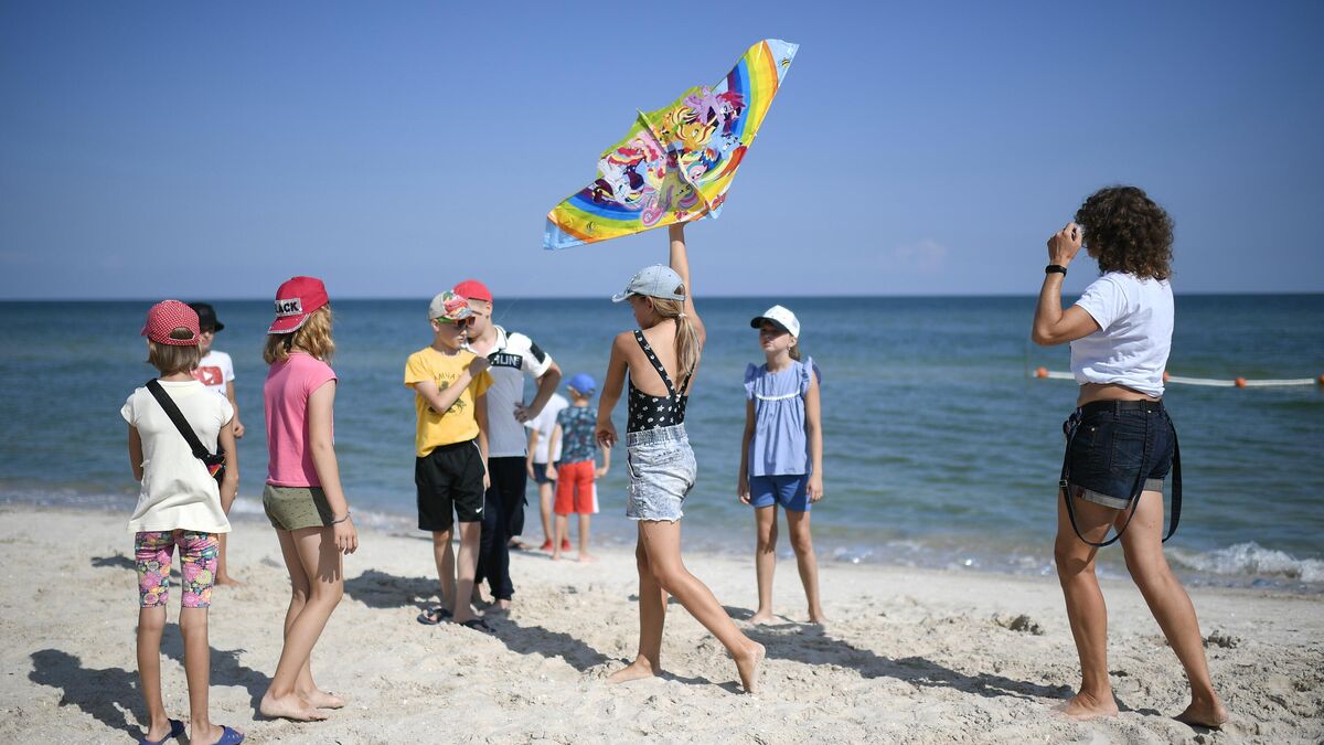 Children play on a beach at a children’s camp