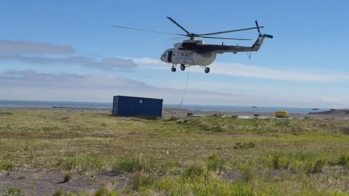 A helicopter delivers a habitation module 