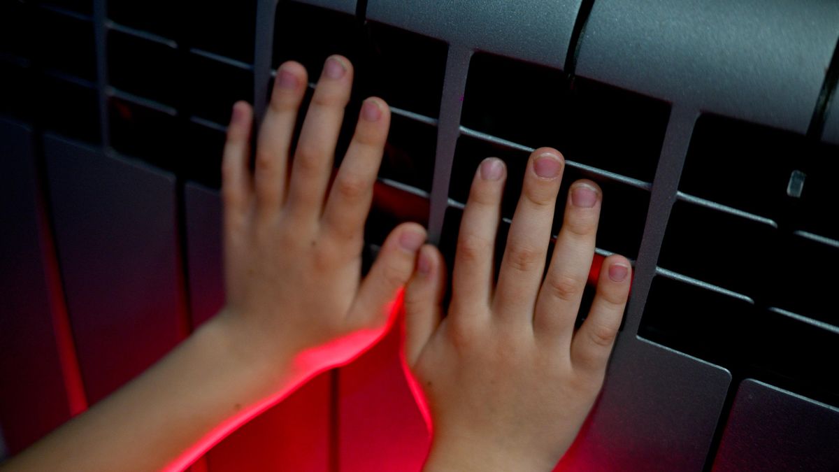 A child warming hands by a radiator